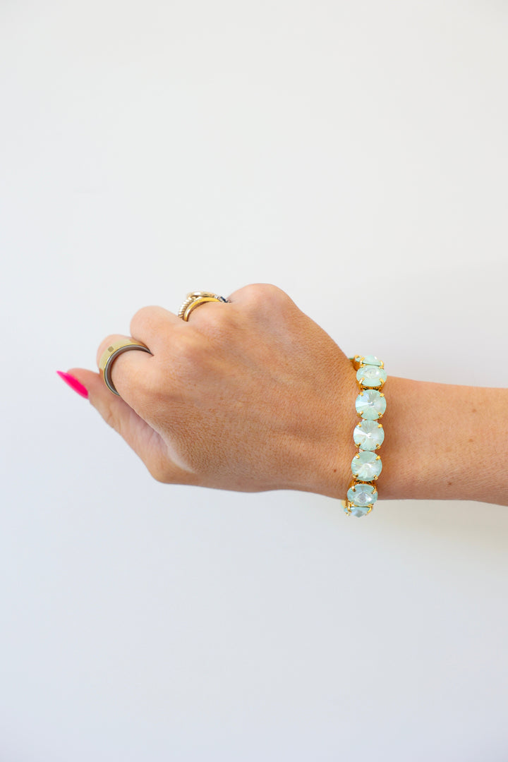 Hand wearing Tova Dereka bracelet with mint green gemstones in gold setting