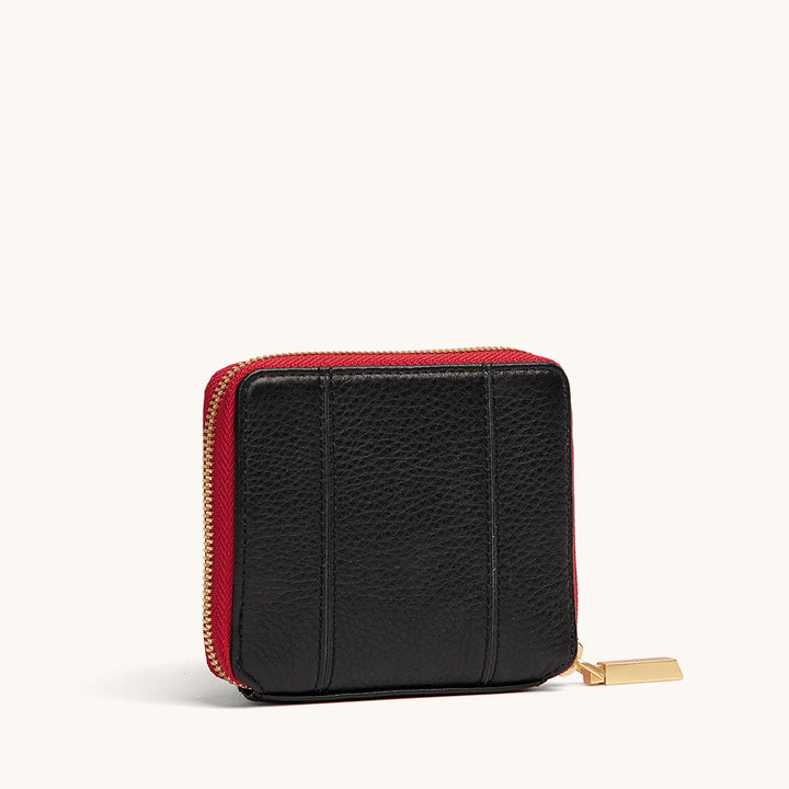 Hammitt 5 North zip-around wallet in black leather with red zip and gold hardware, back view