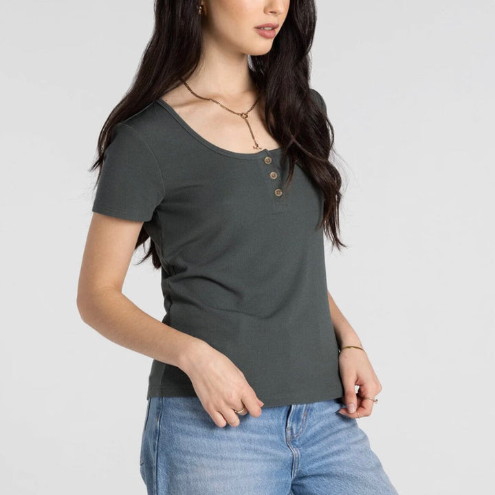 Woman wearing dark olive ribbed Henley short-sleeve top with button detail and blue jeans
