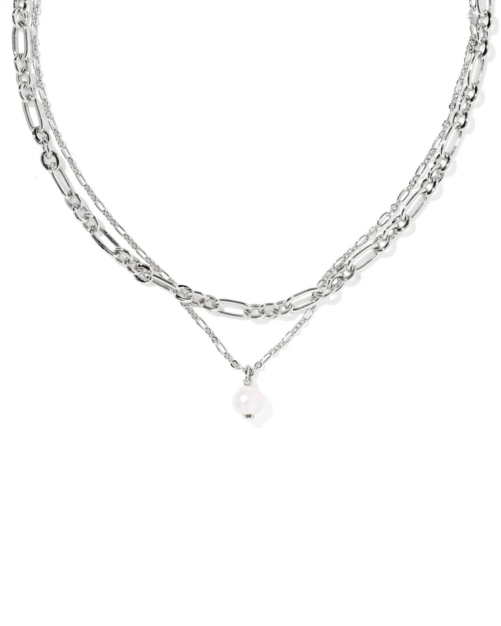 Layered silver chain necklace with a pearl pendant on a white background