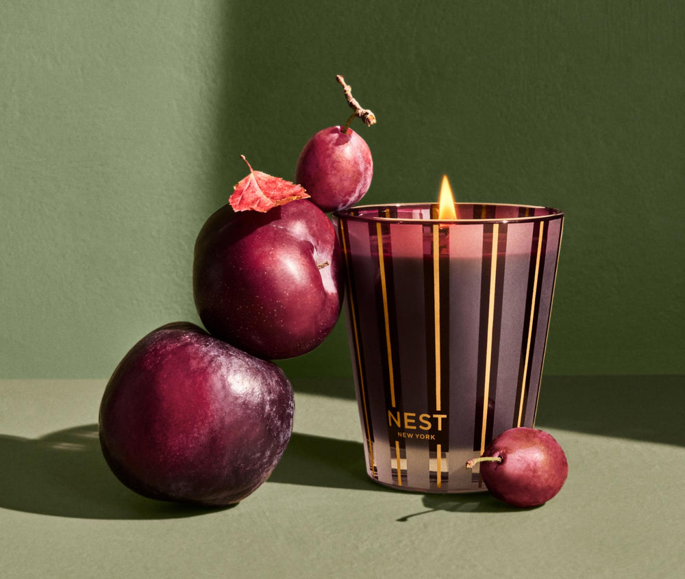 NEST New York Autumn Plum Classic Candle in purple striped glass vessel with fresh plums