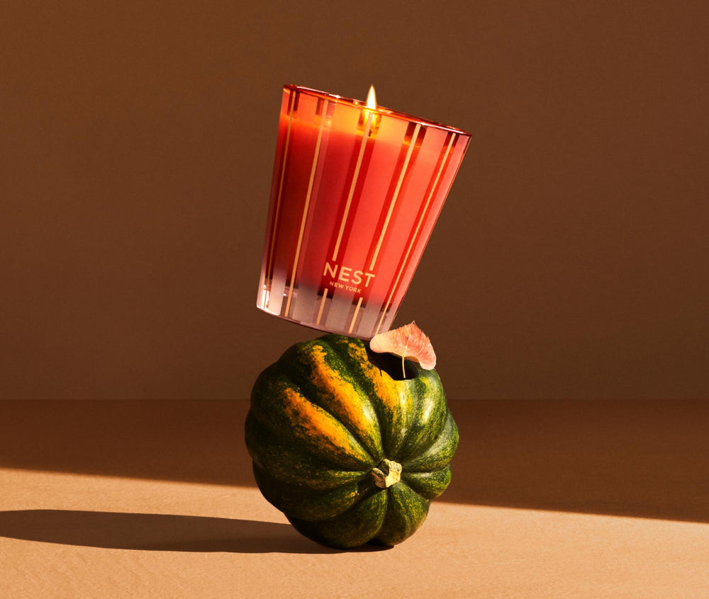 NEST New York Pumpkin Chai classic candle in red striped glass balanced on acorn squash