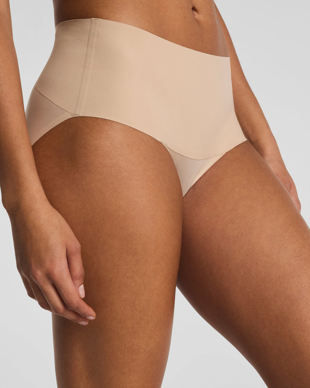 Spanx Undie-Tectable Brief in nude chai color on model against clean background