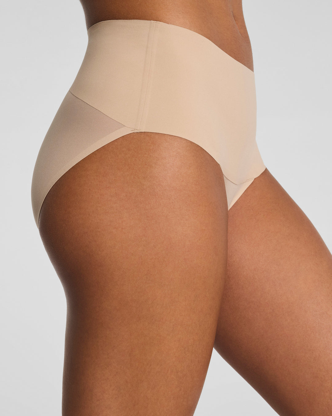 Spanx Undie-Tectable Brief in nude chai color on model against white background