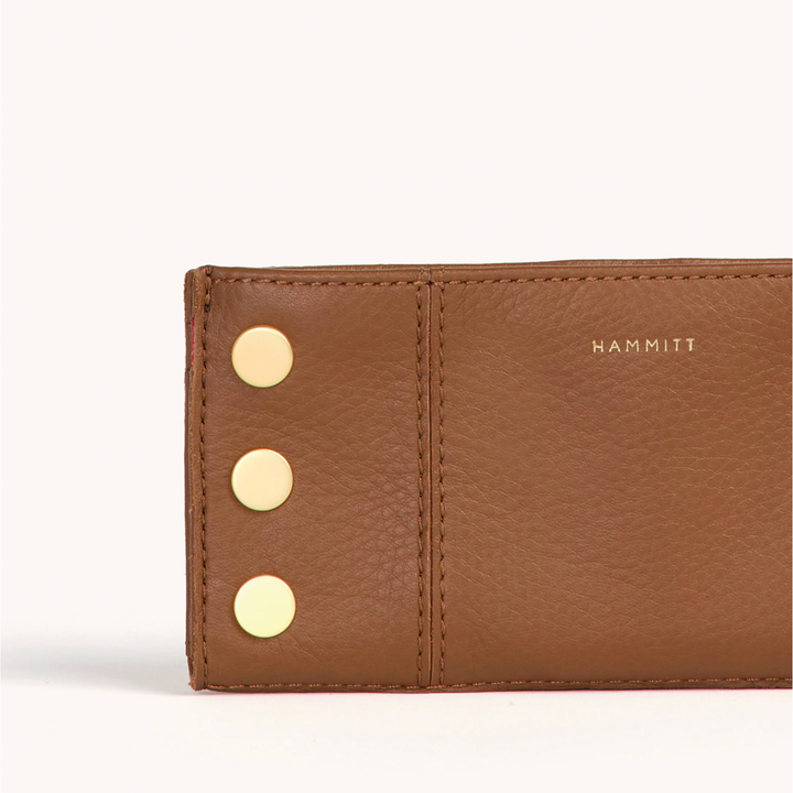 Hammitt 110 North wallet detail showing tan pebbled leather and three gold studs with red interior